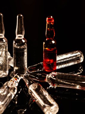 Tıbbi ampuller kapanıyor. Bir sürü ampul. Masada cam ampuller var. İlaç ile dağılmış ampuller.