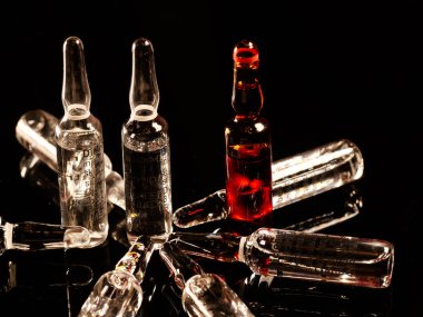 Tıbbi ampuller kapanıyor. Bir sürü ampul. Masada cam ampuller var. İlaç ile dağılmış ampuller.