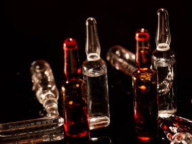 Tıbbi ampuller kapanıyor. Bir sürü ampul. Masada cam ampuller var. İlaç ile dağılmış ampuller.