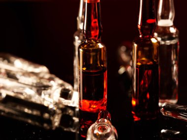 Tıbbi ampuller kapanıyor. Bir sürü ampul. Masada cam ampuller var. İlaç ile dağılmış ampuller.