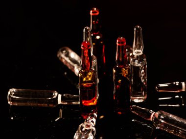 Tıbbi ampuller kapanıyor. Bir sürü ampul. Masada cam ampuller var. İlaç ile dağılmış ampuller.