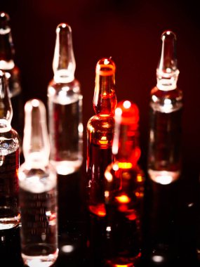 Tıbbi ampuller kapanıyor. Bir sürü ampul. Masada cam ampuller var. İlaç ile dağılmış ampuller.