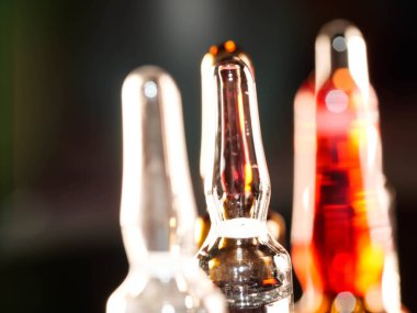 Tıbbi ampuller kapanıyor. Bir sürü ampul. Masada cam ampuller var. İlaç ile dağılmış ampuller.