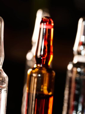 Tıbbi ampuller kapanıyor. Bir sürü ampul. Masada cam ampuller var. İlaç ile dağılmış ampuller.