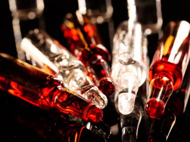 Tıbbi ampuller kapanıyor. Bir sürü ampul. Masada cam ampuller var. İlaç ile dağılmış ampuller.