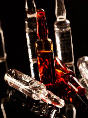 Tıbbi ampuller kapanıyor. Bir sürü ampul. Masada cam ampuller var. İlaç ile dağılmış ampuller.