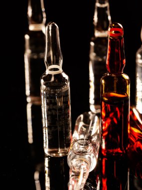 Tıbbi ampuller kapanıyor. Bir sürü ampul. Masada cam ampuller var. İlaç ile dağılmış ampuller.