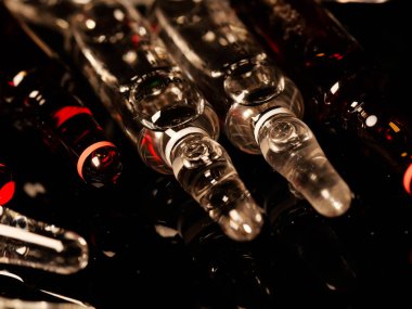 Tıbbi ampuller kapanıyor. Bir sürü ampul. Masada cam ampuller var. İlaç ile dağılmış ampuller.