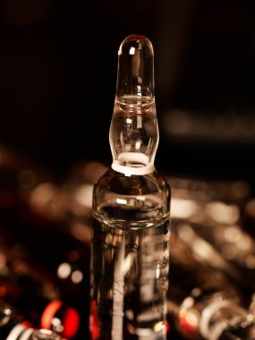 Tıbbi ampuller kapanıyor. Bir sürü ampul. Masada cam ampuller var. İlaç ile dağılmış ampuller.