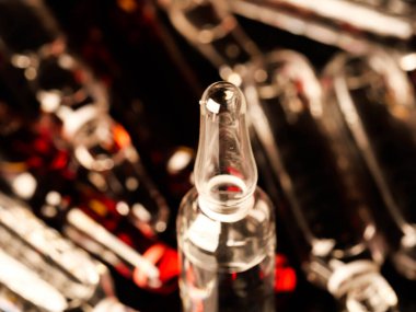 Tıbbi ampuller kapanıyor. Bir sürü ampul. Masada cam ampuller var. İlaç ile dağılmış ampuller.