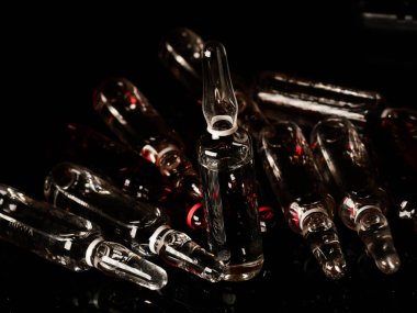 Tıbbi ampuller kapanıyor. Bir sürü ampul. Masada cam ampuller var. İlaç ile dağılmış ampuller.