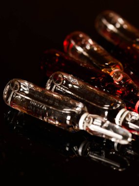 Tıbbi ampuller kapanıyor. Bir sürü ampul. Masada cam ampuller var. İlaç ile dağılmış ampuller.