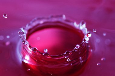 Renkli su damlası, daire şeklinde dalgalar, biraz su, yakın plan..