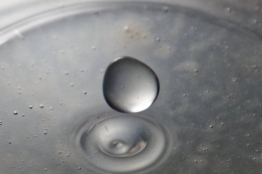 Renkli su damlası, daire şeklinde dalgalar, biraz su, yakın plan..