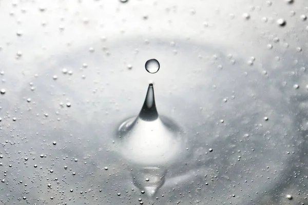 Colored water drop, circle ripples, splash of water, closeup.