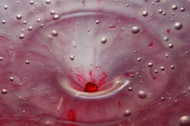 Renkli su damlası, daire şeklinde dalgalar, biraz su, yakın plan..