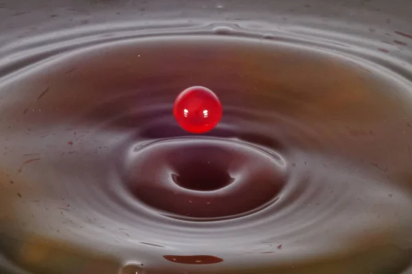Colored water drop, circle ripples, splash of water, closeup.