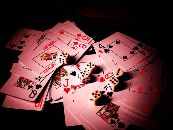 Dice and playing cards, black background