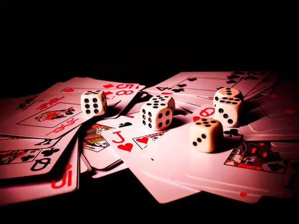 Dice and playing cards, black background