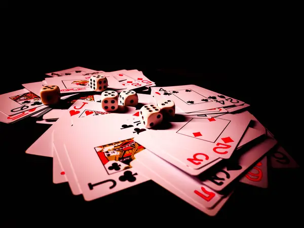 Dice and playing cards, black background