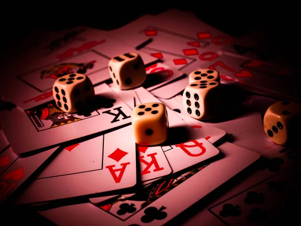 Dice and playing cards, black background