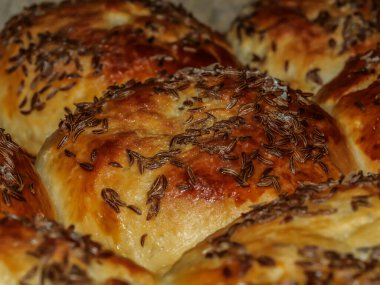 Siyah güveçte pişmiş kimyon yumurtalı çörekler.