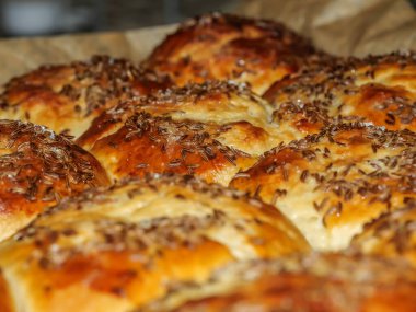 Siyah güveçte pişmiş kimyon yumurtalı çörekler.