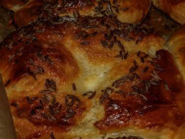 Siyah güveçte pişmiş kimyon yumurtalı çörekler.