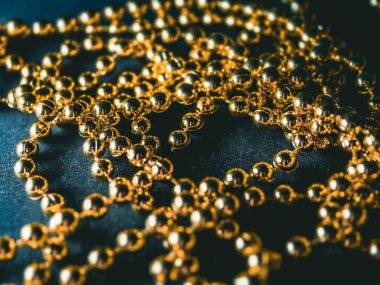 İnciler. Koyu bir arkaplanda, koyu bir masada altın gümüş inci boncuklar.