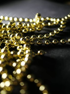 İnciler. Koyu bir arkaplanda, koyu bir masada altın gümüş inci boncuklar.