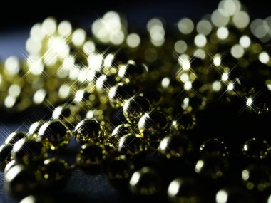 İnciler. Koyu bir arkaplanda, koyu bir masada altın gümüş inci boncuklar.