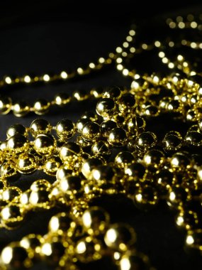 İnciler. Koyu bir arkaplanda, koyu bir masada altın gümüş inci boncuklar.