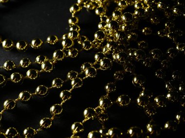 İnciler. Koyu bir arkaplanda, koyu bir masada altın gümüş inci boncuklar.