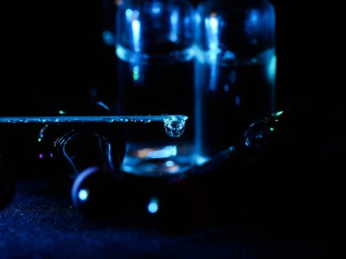 Tıbbi ampuller kapanıyor. Bir sürü ampul. Masada cam ampuller var. İlaç ile dağılmış ampuller.