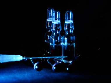 Tıbbi ampuller kapanıyor. Bir sürü ampul. Masada cam ampuller var. İlaç ile dağılmış ampuller.