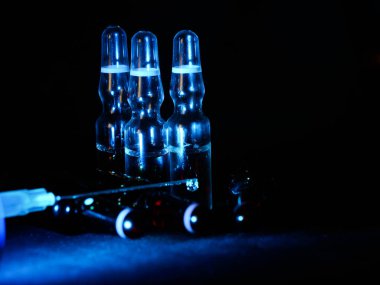 Tıbbi ampuller kapanıyor. Bir sürü ampul. Masada cam ampuller var. İlaç ile dağılmış ampuller.