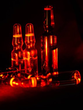 Tıbbi ampuller kapanıyor. Bir sürü ampul. Masada cam ampuller var. İlaç ile dağılmış ampuller.