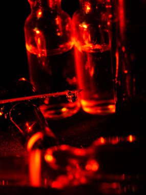 Tıbbi ampuller kapanıyor. Bir sürü ampul. Masada cam ampuller var. İlaç ile dağılmış ampuller.