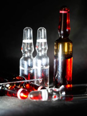 Tıbbi ampuller kapanıyor. Bir sürü ampul. Masada cam ampuller var. İlaç ile dağılmış ampuller.