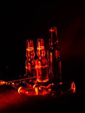 Tıbbi ampuller kapanıyor. Bir sürü ampul. Masada cam ampuller var. İlaç ile dağılmış ampuller.