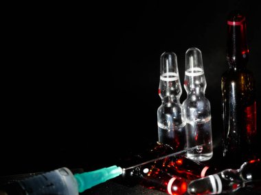 Tıbbi ampuller kapanıyor. Bir sürü ampul. Masada cam ampuller var. İlaç ile dağılmış ampuller.