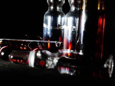 Tıbbi ampuller kapanıyor. Bir sürü ampul. Masada cam ampuller var. İlaç ile dağılmış ampuller.