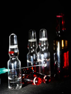 Tıbbi ampuller kapanıyor. Bir sürü ampul. Masada cam ampuller var. İlaç ile dağılmış ampuller.