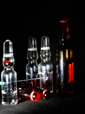 Tıbbi ampuller kapanıyor. Bir sürü ampul. Masada cam ampuller var. İlaç ile dağılmış ampuller.