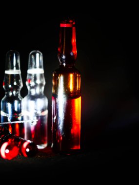 Tıbbi ampuller kapanıyor. Bir sürü ampul. Masada cam ampuller var. İlaç ile dağılmış ampuller.