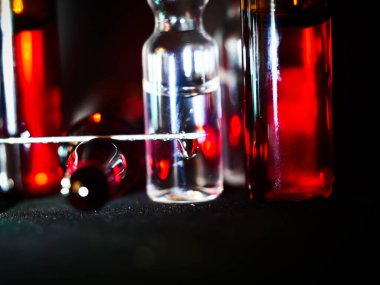 Tıbbi ampuller kapanıyor. Bir sürü ampul. Masada cam ampuller var. İlaç ile dağılmış ampuller.