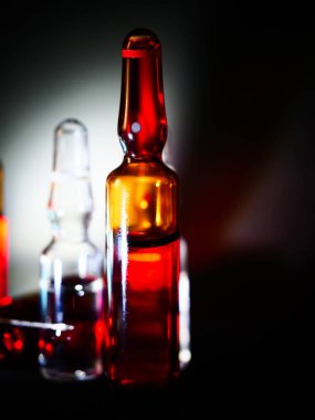 Tıbbi ampuller kapanıyor. Bir sürü ampul. Masada cam ampuller var. İlaç ile dağılmış ampuller.