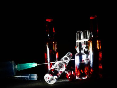 Tıbbi ampuller kapanıyor. Bir sürü ampul. Masada cam ampuller var. İlaç ile dağılmış ampuller.