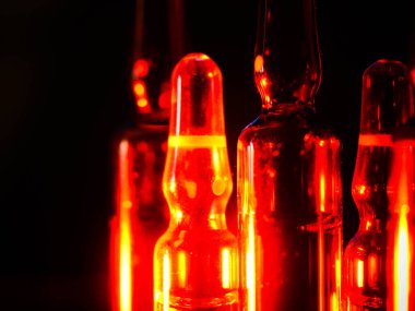 Tıbbi ampuller kapanıyor. Bir sürü ampul. Masada cam ampuller var. İlaç ile dağılmış ampuller.