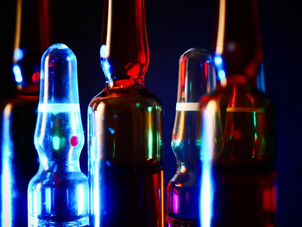 Tıbbi ampuller kapanıyor. Bir sürü ampul. Masada cam ampuller var. İlaç ile dağılmış ampuller.